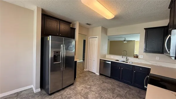 a view of a kitchen with a sink and refrigerator