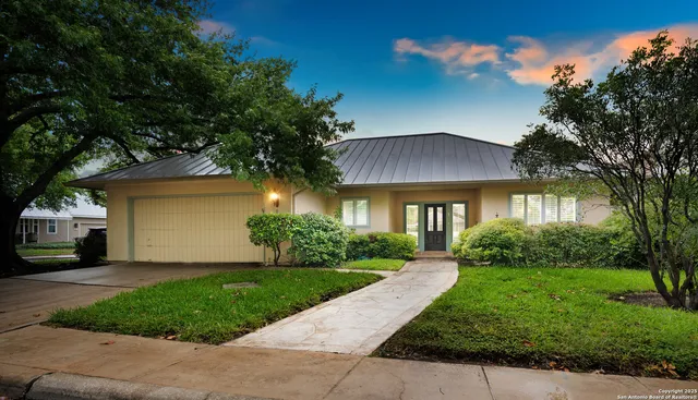 a front view of a house with a garden and yard