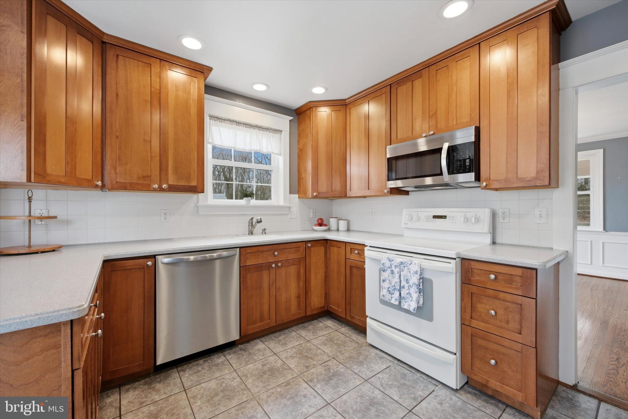 436 Kerr Lane Springfield, PA 19064 - Photo 11 of 52 a kitchen with stainless steel appliances granite countertop wooden cabinets a stove top oven a sink and dishwasher