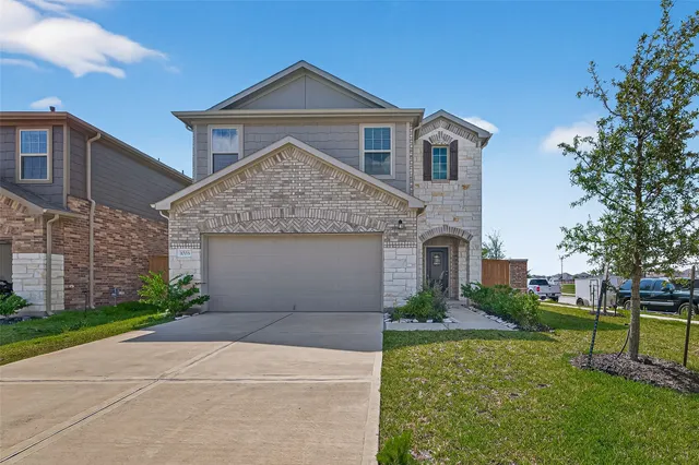 a front view of a house with a yard and garage