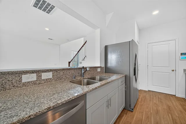 a kitchen with sink refrigerator and cabinets