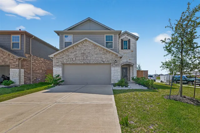 a front view of a house with a yard and garage