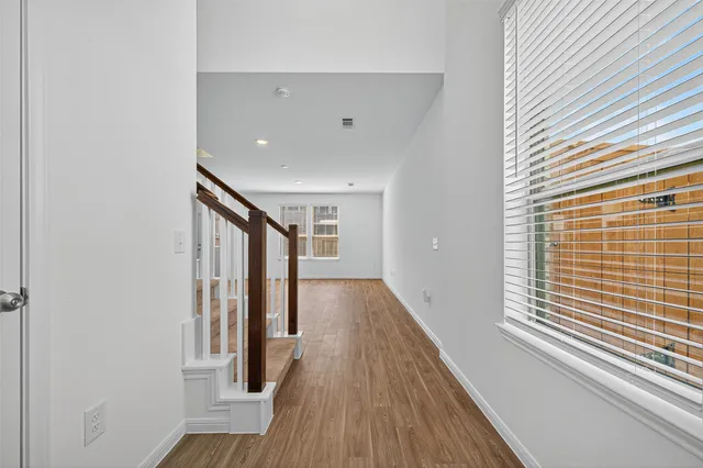 a view of a hallway with wooden floor and staircase