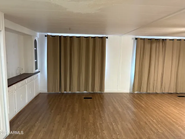 a view of a room with wooden floor and windows