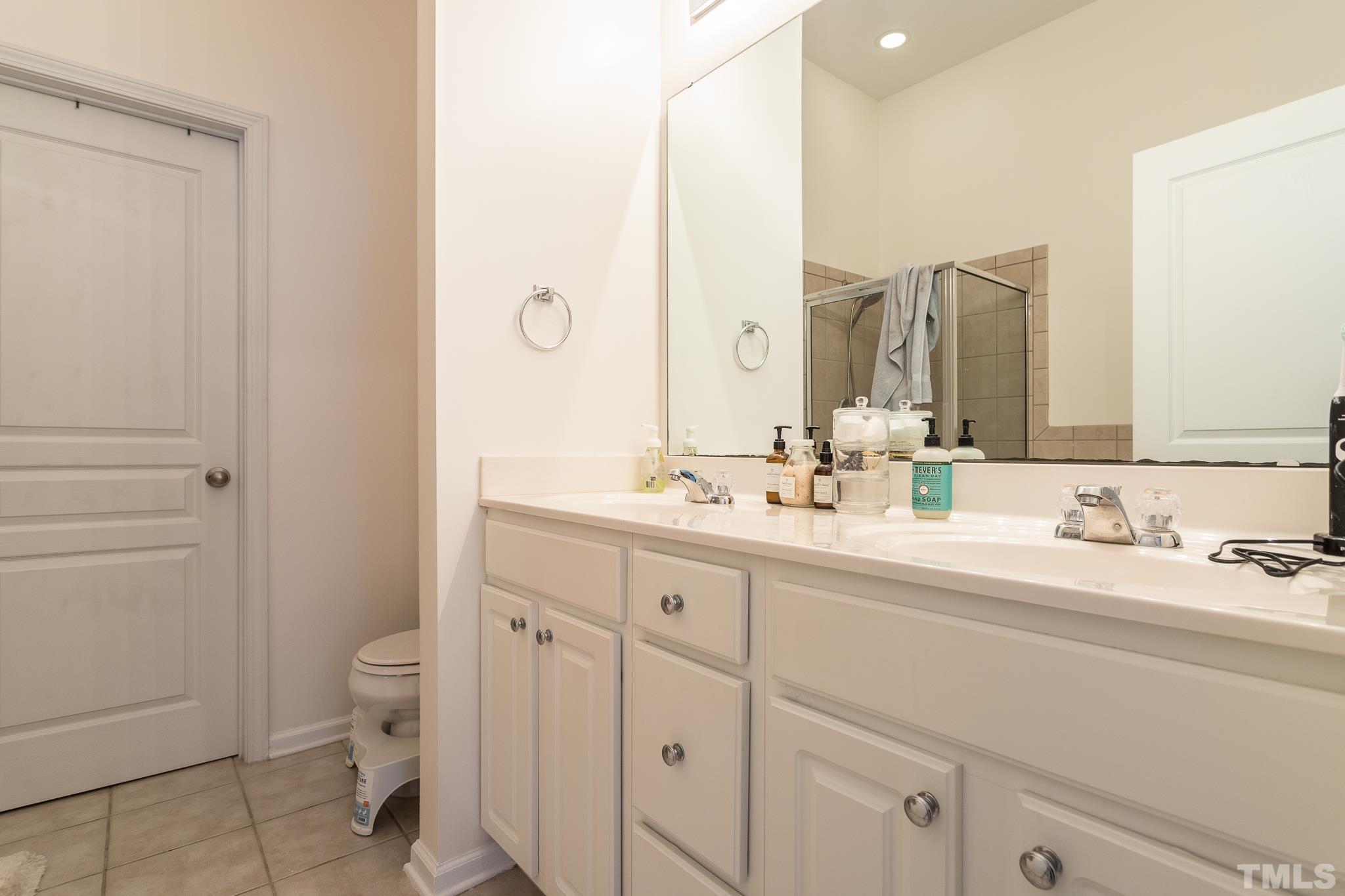 5050 Amber Clay Lane Raleigh, NC 27612 - Photo 16 of 23 a bathroom with a double vanity sink mirror and toilet