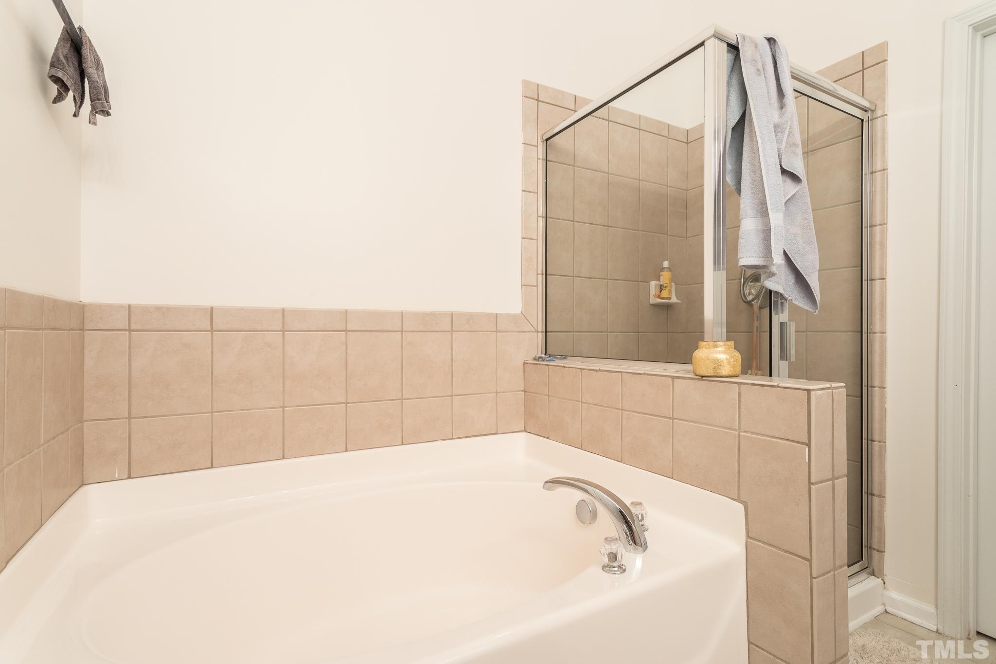5050 Amber Clay Lane Raleigh, NC 27612 - Photo 17 of 23 a bathroom with a bathtub and shower