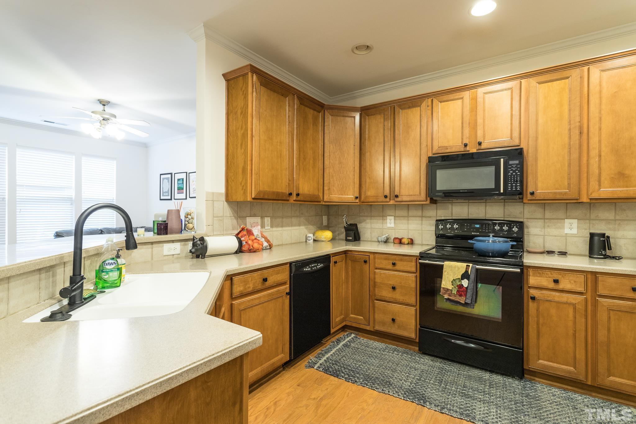 5050 Amber Clay Lane Raleigh, NC 27612 - Photo 7 of 23 a kitchen with stainless steel appliances granite countertop a stove a sink and a microwave