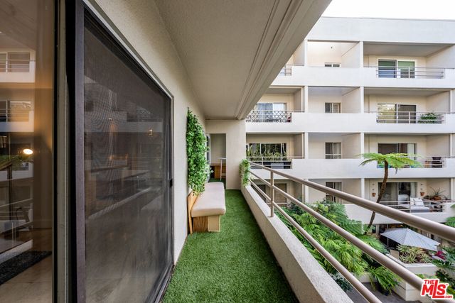 a view of balcony with two large windows and a potted plant