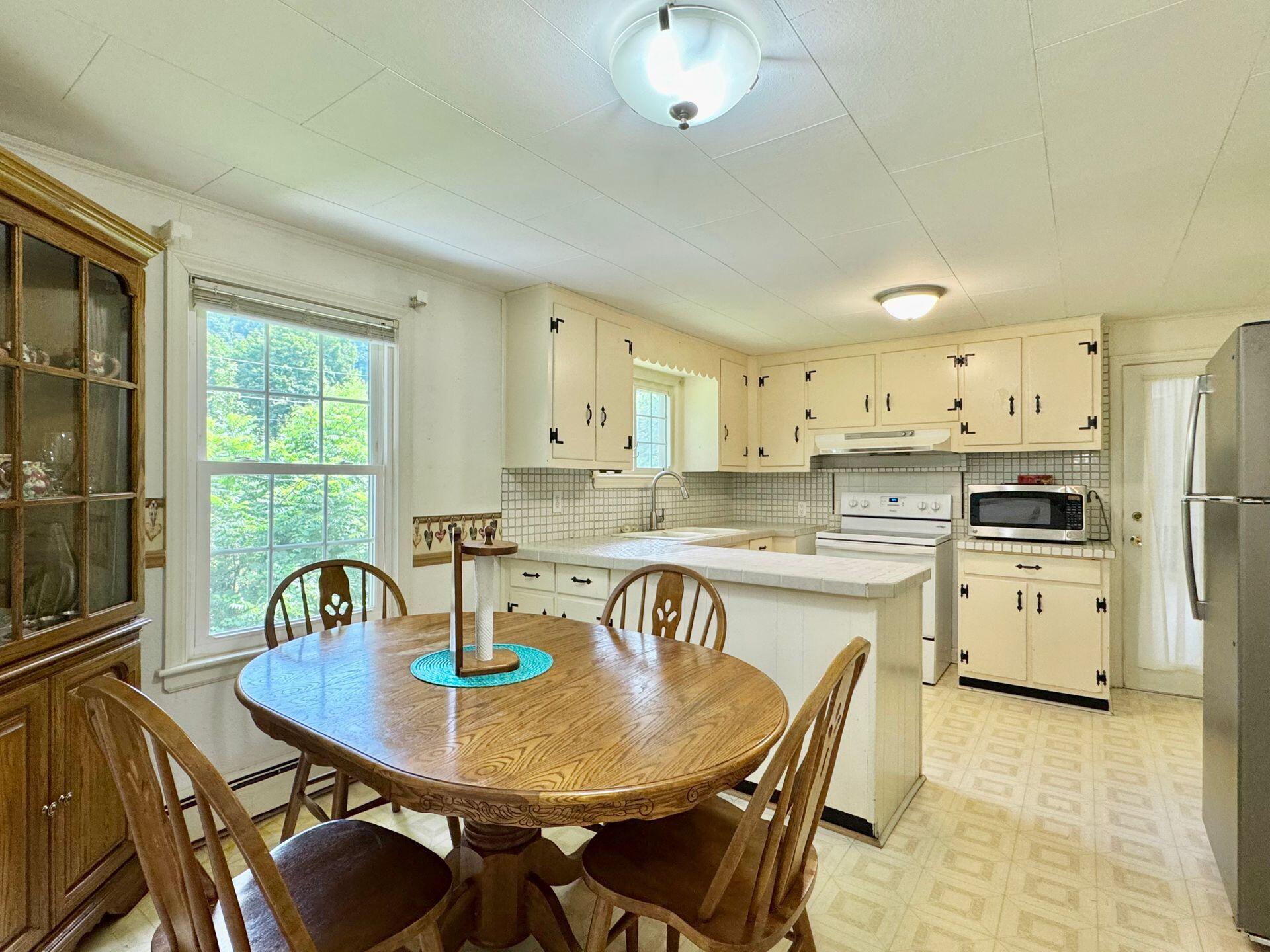 2643 Wades Gap Road Callaway, VA 24067 - Photo 13 of 104 a kitchen with stainless steel appliances granite countertop a dining table chairs and a refrigerator