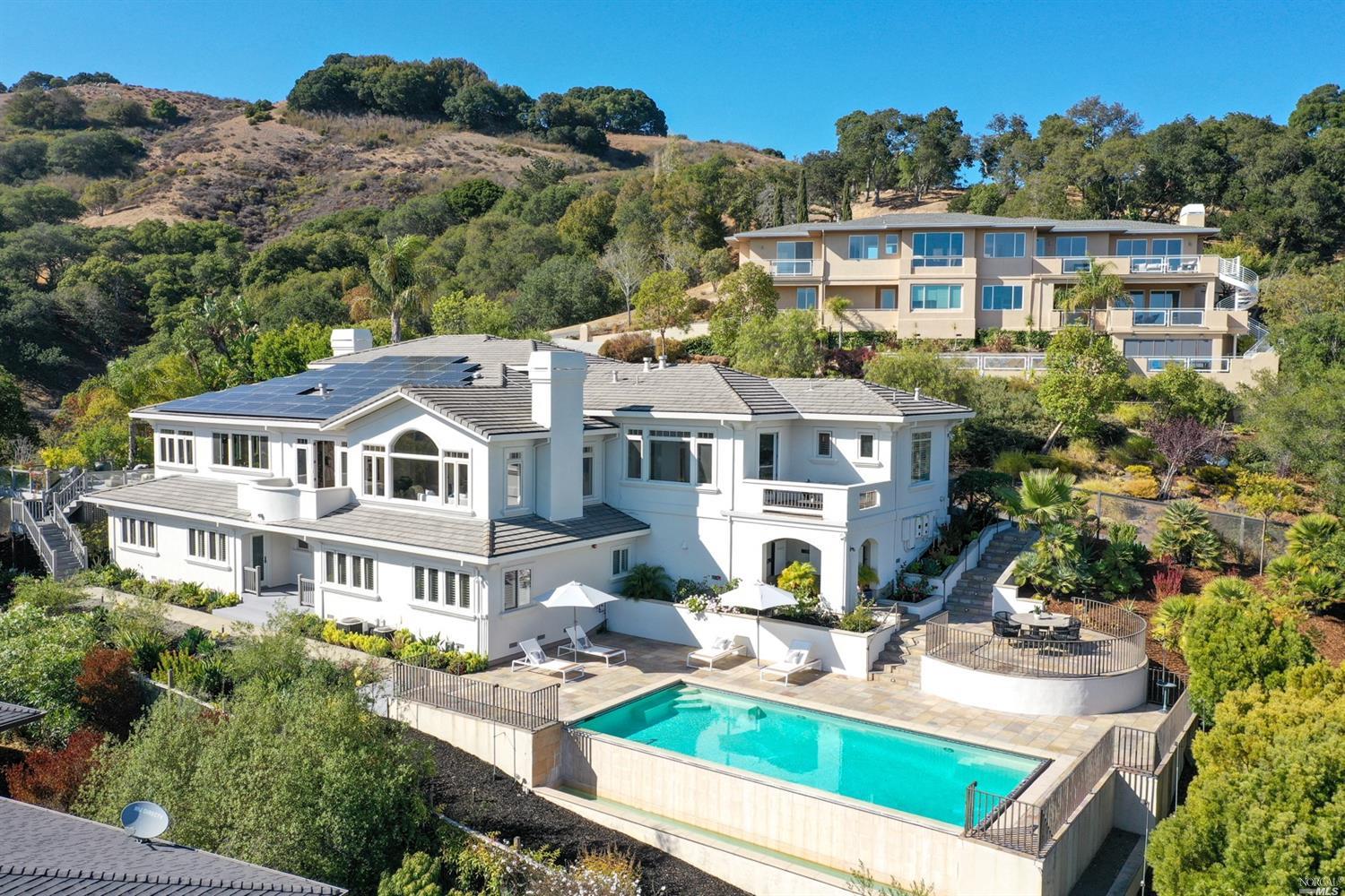 an aerial view of a house with swimming pool and a yard