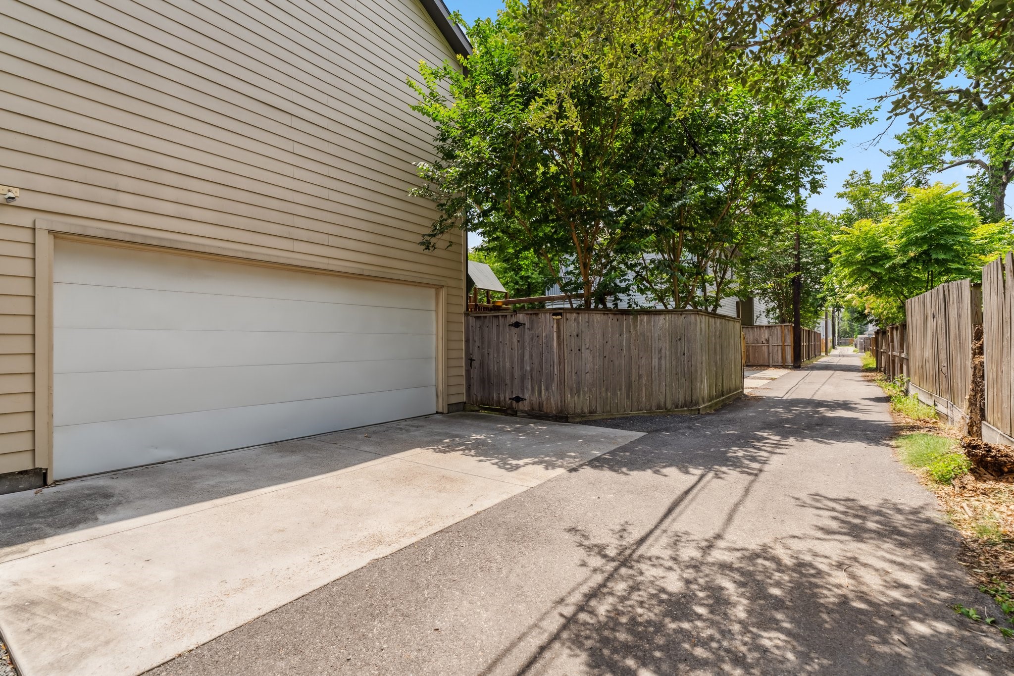 815 East 27th Street Houston, TX 77009 - Photo 38 of 44 A rare find in the heights- this home is located at the end of a short paved alleyway with extra space for play or parking. The alley entrance was freshly paved in 2023. The attached two-car garage boasts installed track shelving (2021), along with an EV charger and generator plug-in added in 2023, providing both storage and modern amenities.