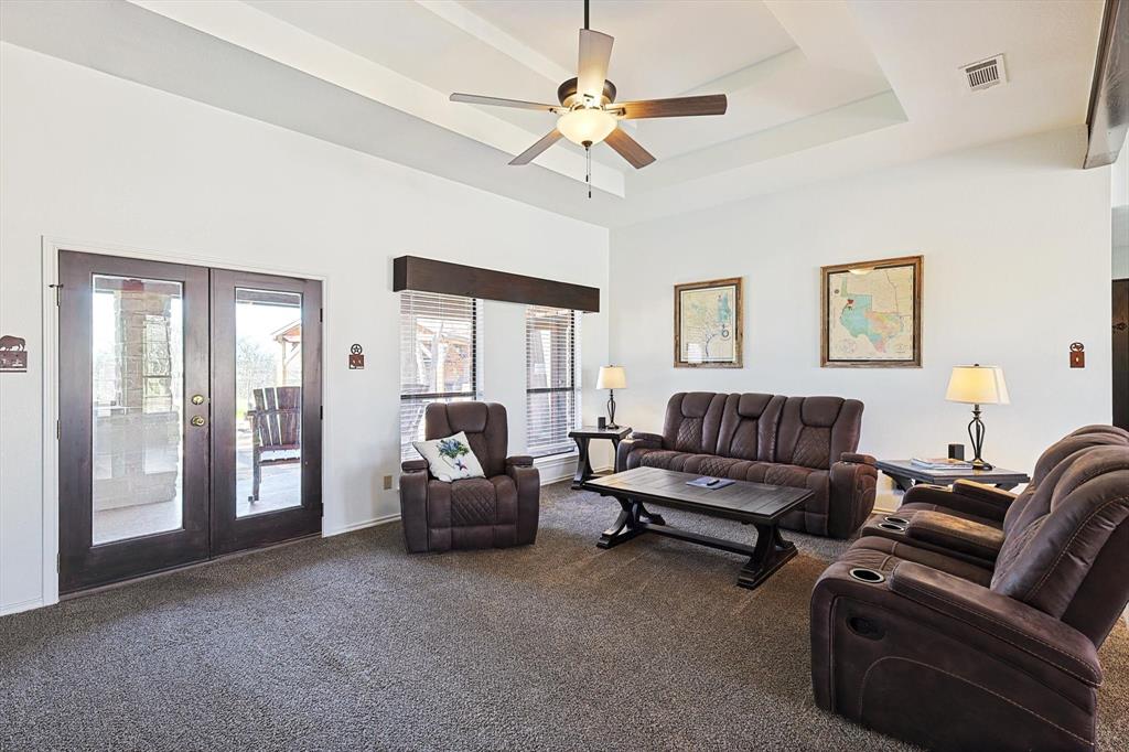 7185 Mesquite Ridge Sanger, TX 76266 - Photo 12 of 40 Carpeted living room with french doors, ceiling fan, and a raised ceiling