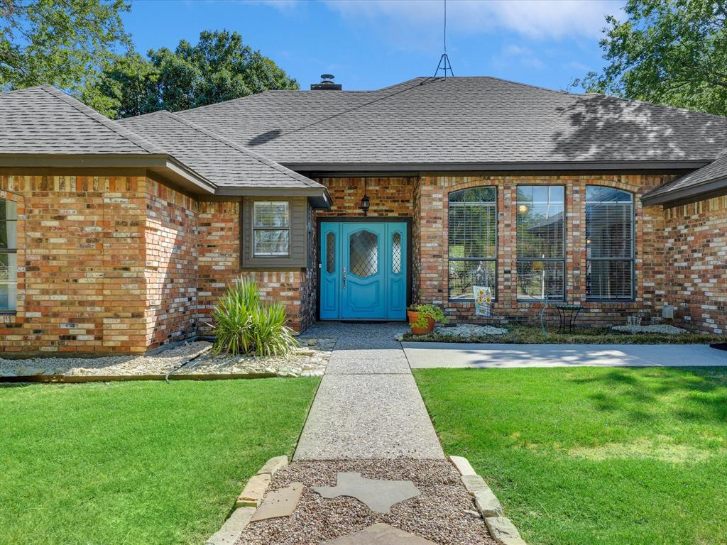 7185 Mesquite Ridge Sanger, TX 76266 - Photo 3 of 40 Doorway to property featuring brick siding, a lawn, a shingled roof, and a chimney