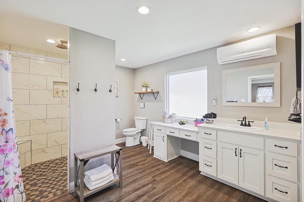 7185 Mesquite Ridge Sanger, TX 76266 - Photo 36 of 40 Bathroom featuring hardwood / wood-style flooring, vanity, walk in shower, toilet, and a wall unit AC