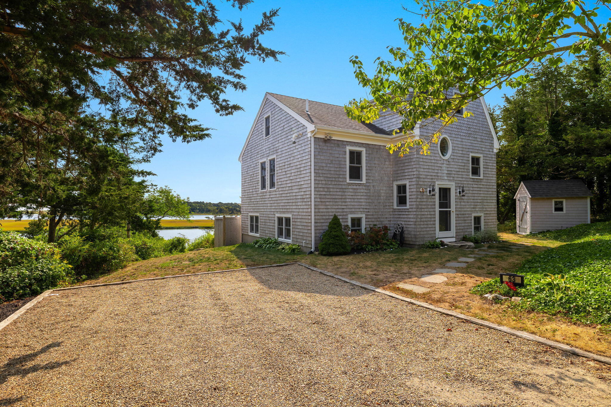 63 Briar Spring Road Orleans, MA 02653 - Photo 1 of 37 a front view of a house with a yard and a garage