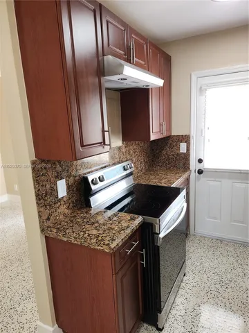 a kitchen with granite countertop stainless steel appliances and wooden cabinets