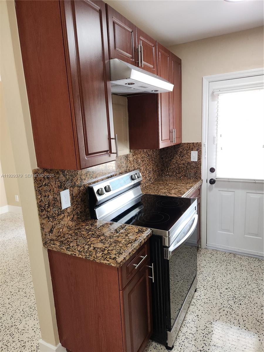 2725 Southwest 25th Street, Unit 4 Miami, FL 33133 - Photo 6 of 9 a kitchen with granite countertop stainless steel appliances and wooden cabinets