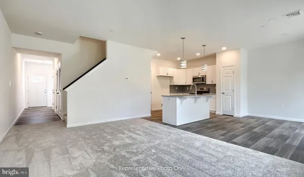 a view of kitchen with kitchen island white cabinets and stainless steel appliances