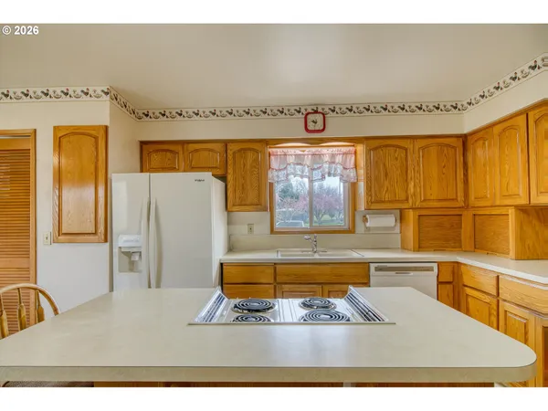 a dining hall with stainless steel appliances granite countertop a sink and a refrigerator