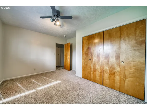 a view of an empty room with a chandelier fan