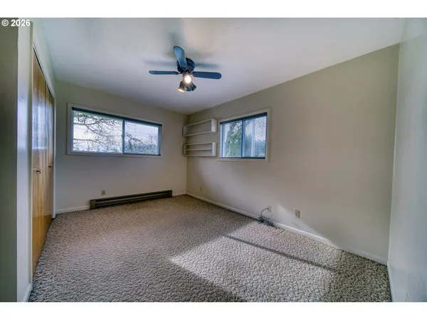 a view of an empty room with window and cabinet