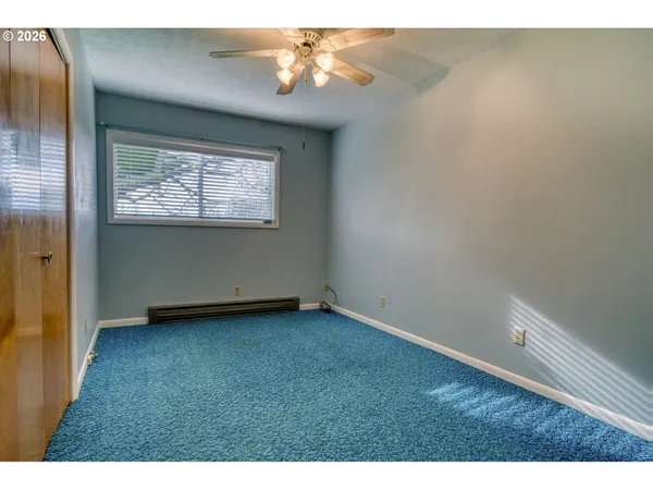 a living room with a couch and a dresser next to a window