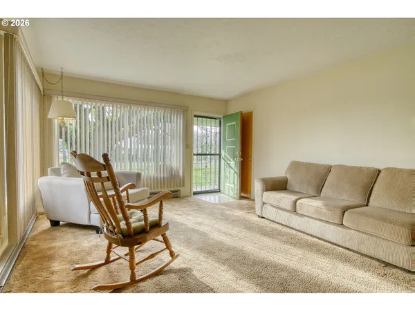 a living room with furniture and a floor to ceiling window