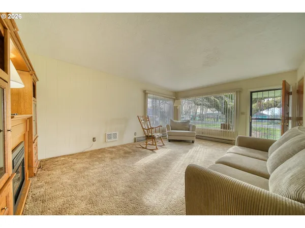 a living room with stainless steel appliances granite countertop furniture and a kitchen view