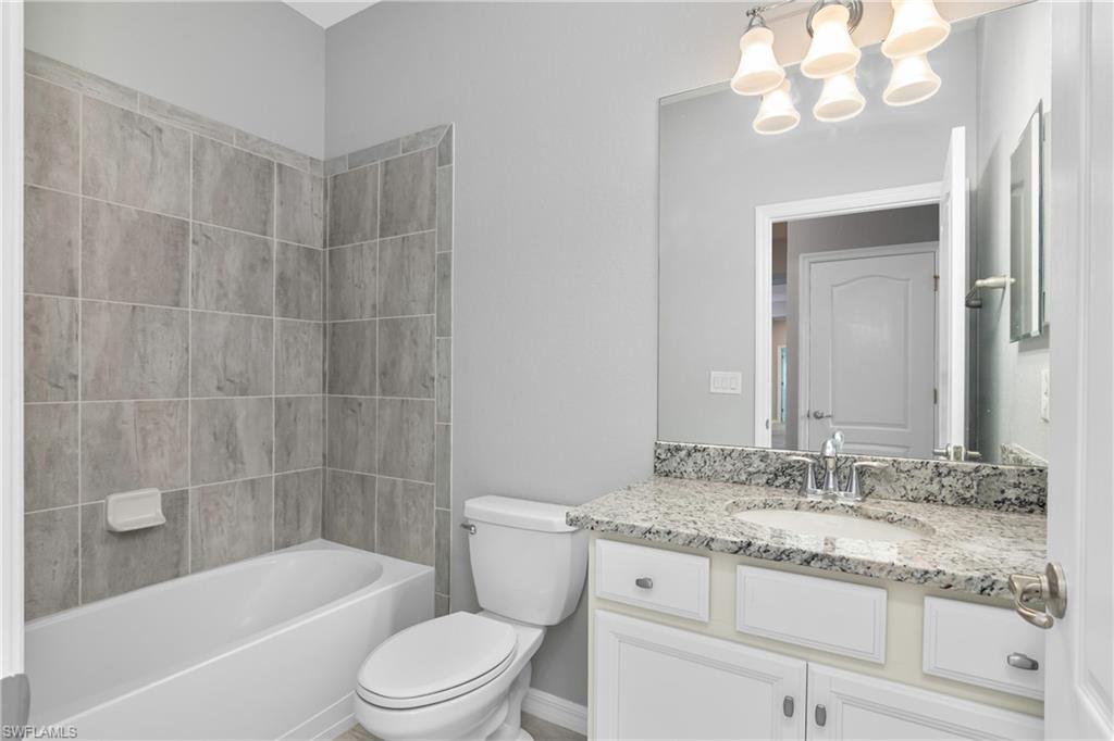 19952 Beverly Park Road Estero, FL 33928 - Photo 16 of 32 a bathroom with a granite countertop sink a toilet and bathtub