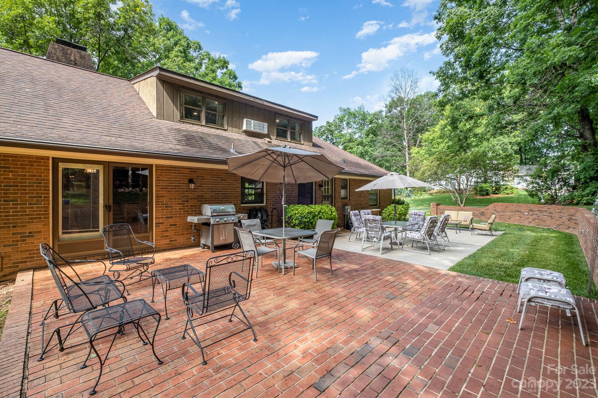 5901 Gate Post Road Charlotte, NC 28211 - Photo 34 of 41 a view of a patio with table and chairs under an umbrella with a barbeque