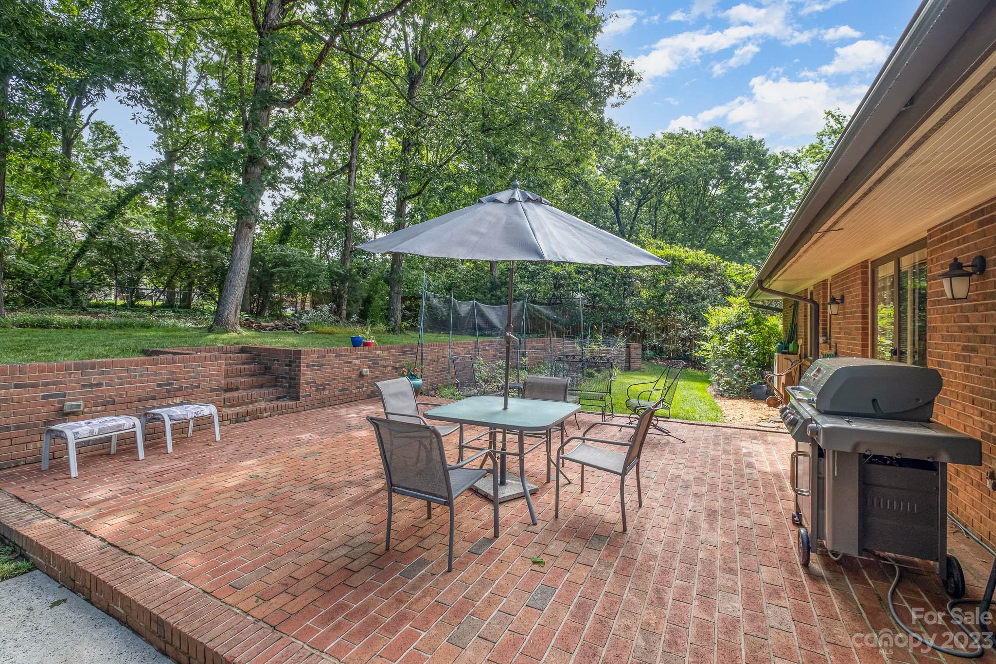 5901 Gate Post Road Charlotte, NC 28211 - Photo 36 of 41 a view of a roof deck with table and chairs under an umbrella with wooden floor and fence