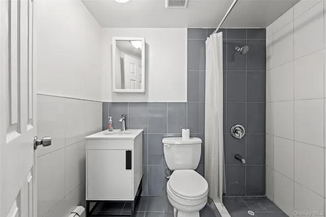 a bathroom with a toilet sink shower and mirror