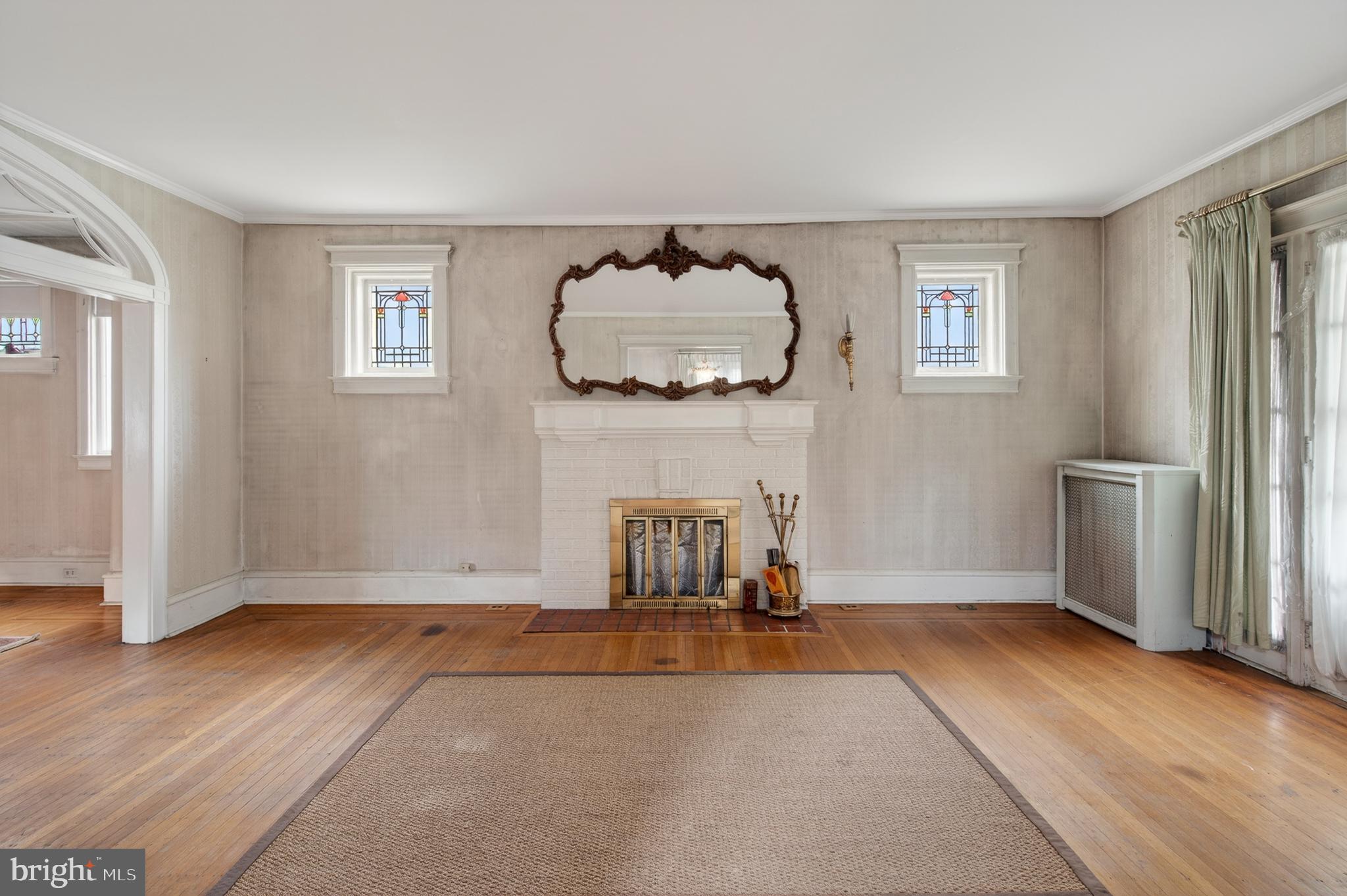 705 East 20th Street Chester, PA 19013 - Photo 6 of 41 an empty room with a fireplace and wooden floor