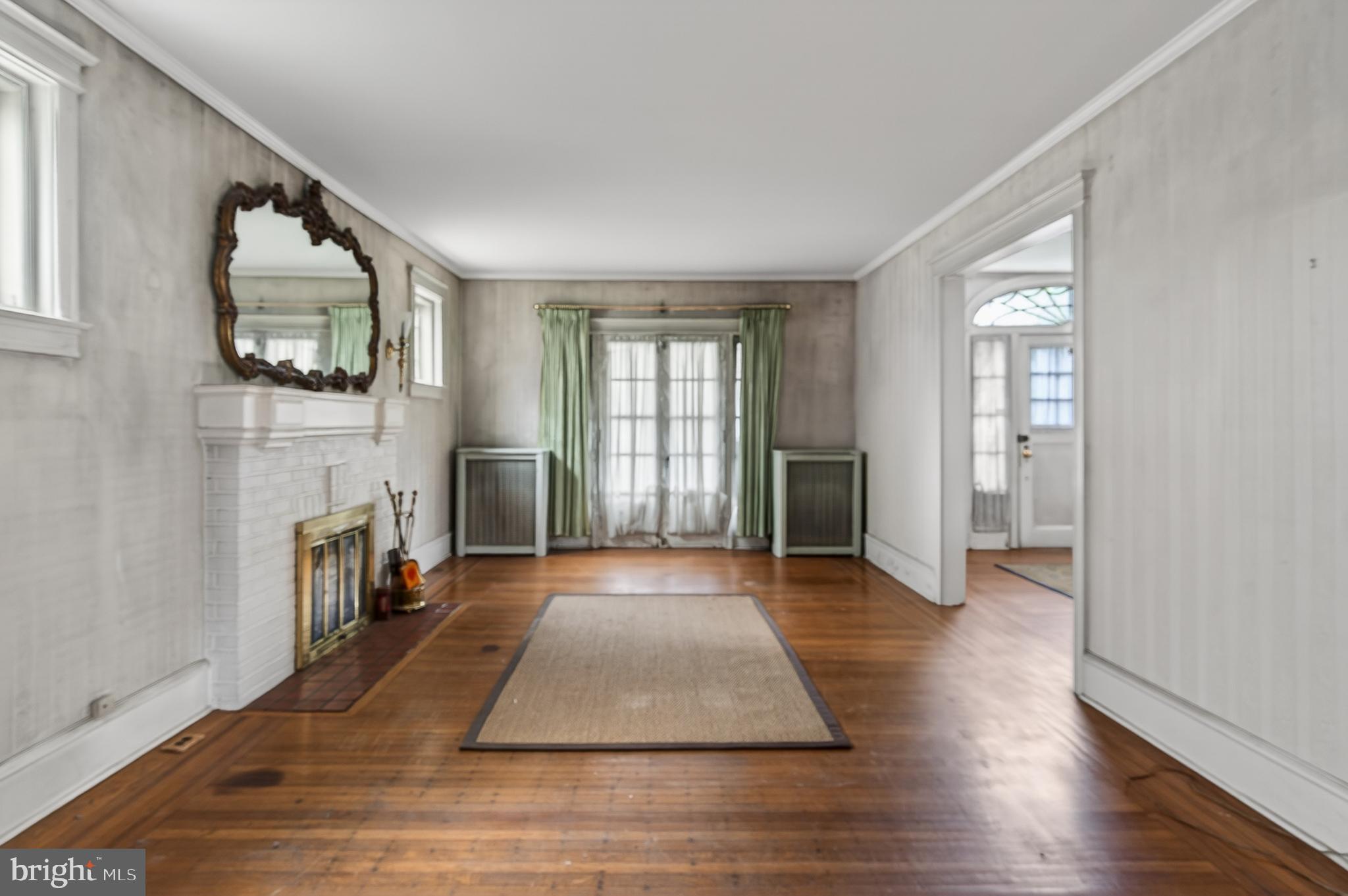 705 East 20th Street Chester, PA 19013 - Photo 8 of 41 an empty room with windows fireplace and wooden floor