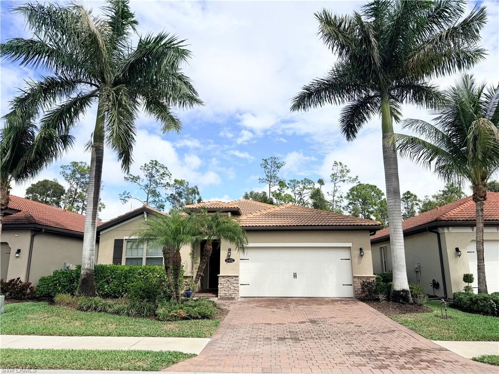a front view of a house with a yard and palm trees