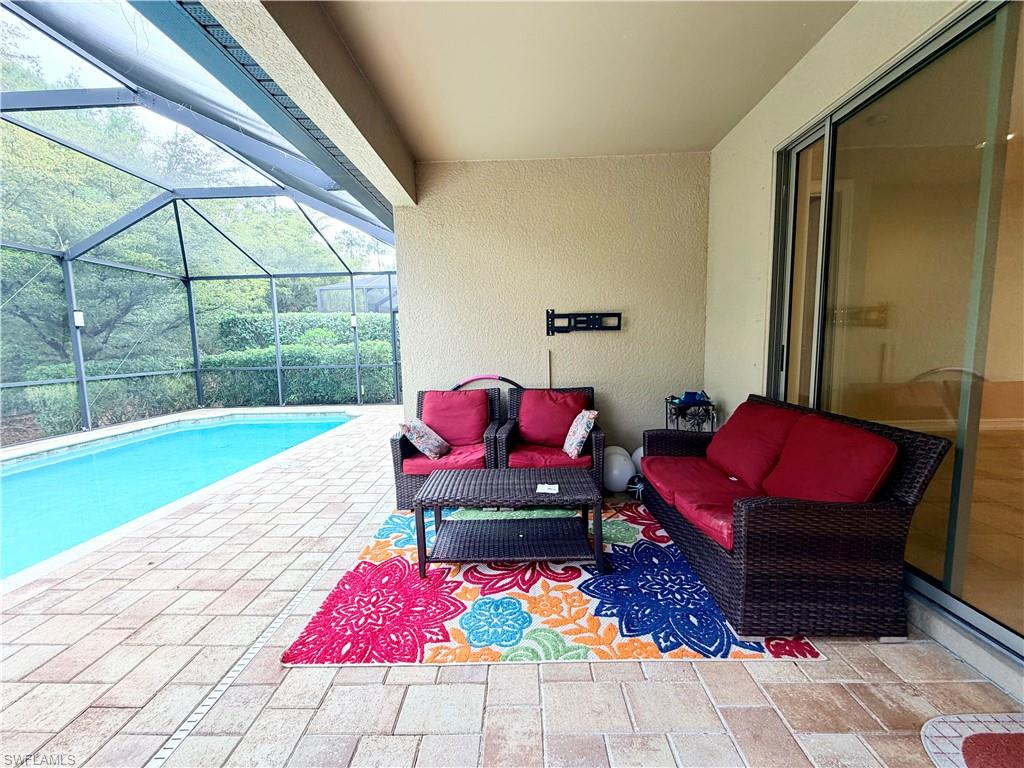 16432 Aberdeen Way Naples, FL 34110 - Photo 20 of 21 a living room with furniture rug and a floor to ceiling window