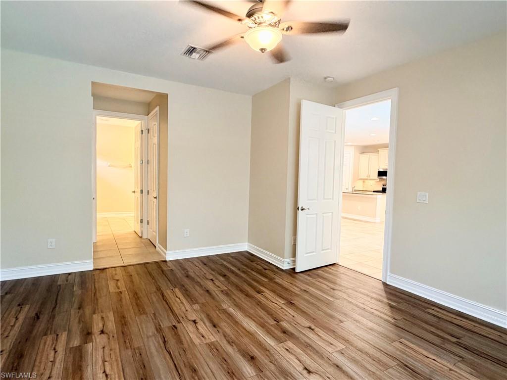 16432 Aberdeen Way Naples, FL 34110 - Photo 8 of 21 a view of empty room with wooden floor and ceiling fan