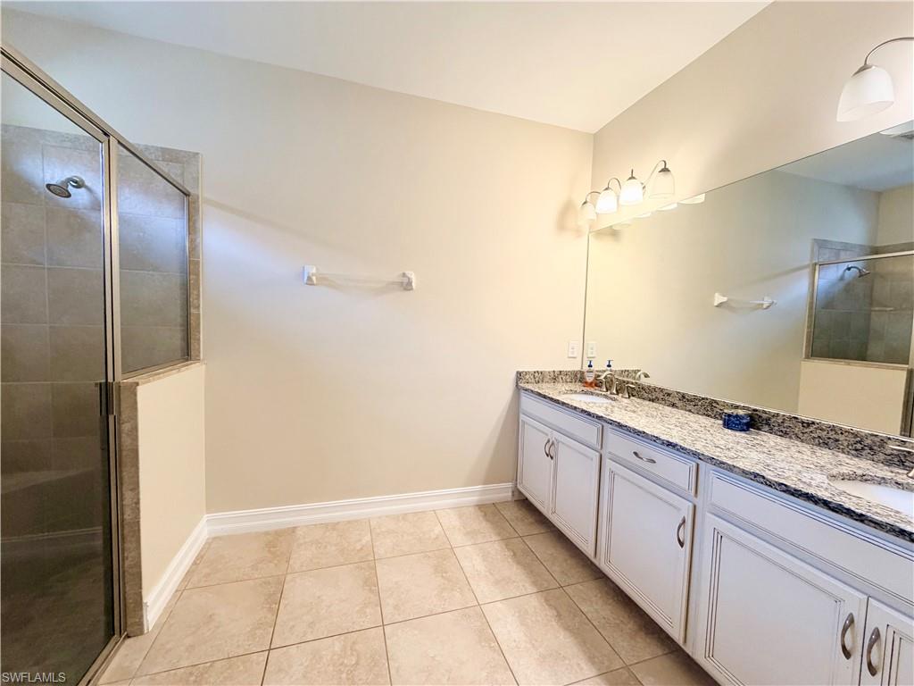 16432 Aberdeen Way Naples, FL 34110 - Photo 10 of 21 a spacious bathroom with a granite countertop sink a mirror and a shower