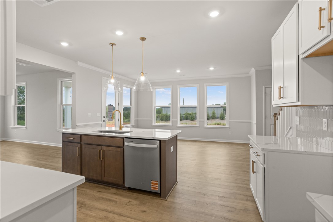 631 Sweetspire Trail, Unit 148 Seneca, SC 29678 - Photo 8 of 36 A well-lit, open-concept kitchen features a central island with a sink and pendant lighting.
