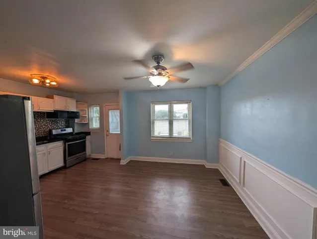 a kitchen with a refrigerator and a stove top oven