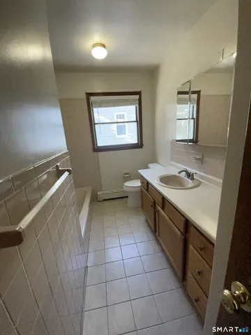 a bathroom with a sink a toilet and mirror