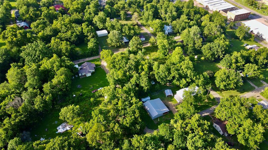 202 Elm Street Roxton, TX 75477 - Photo 15 of 21 a backyard of a house with lots of green space and a fountain