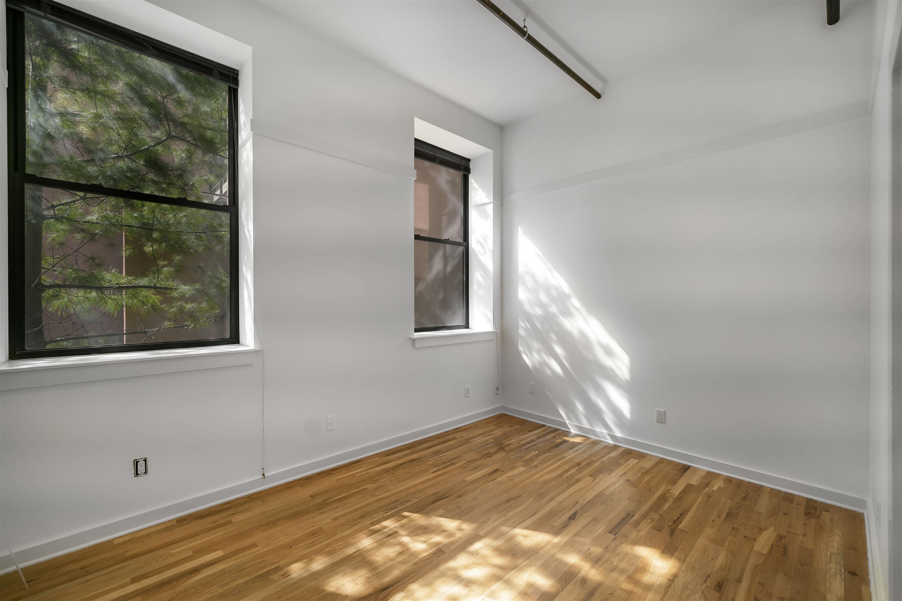 1015 Clinton Street, Unit 204 Hoboken, NJ 07030 - Photo 13 of 22 a view of empty room with wooden floor and fan
