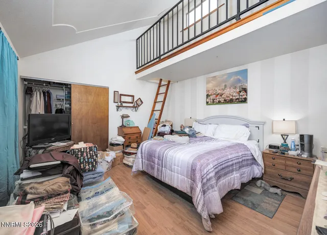 a bedroom with bed tv and window