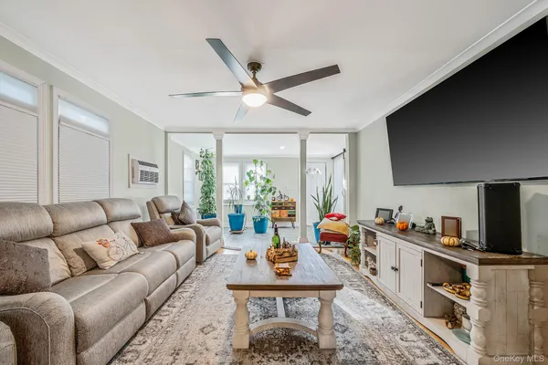 a living room with furniture a flat screen tv and a large window
