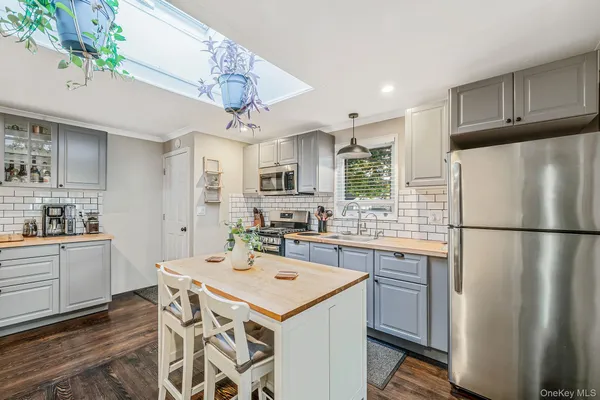 a kitchen with a refrigerator a sink dishwasher a oven with a dining table and chairs