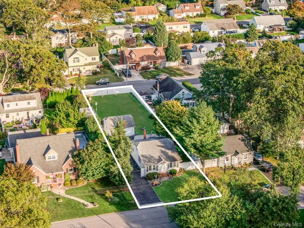 an aerial view of residential houses with outdoor space and trees
