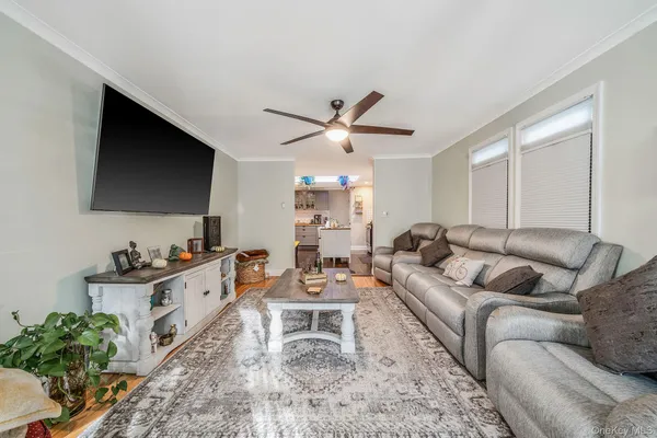 a living room with furniture a flat screen tv and a window