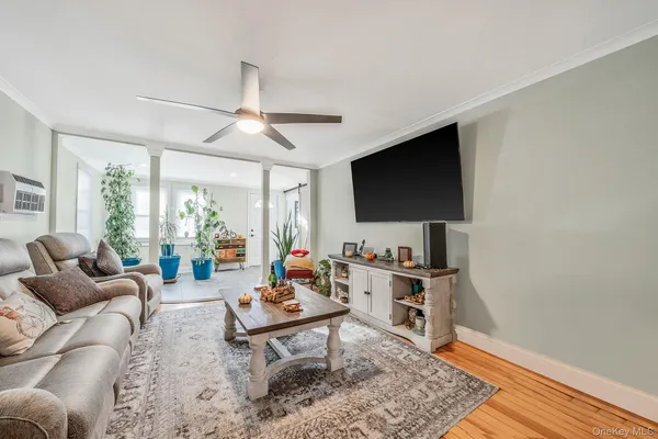 a living room with furniture a flat screen tv and a large window