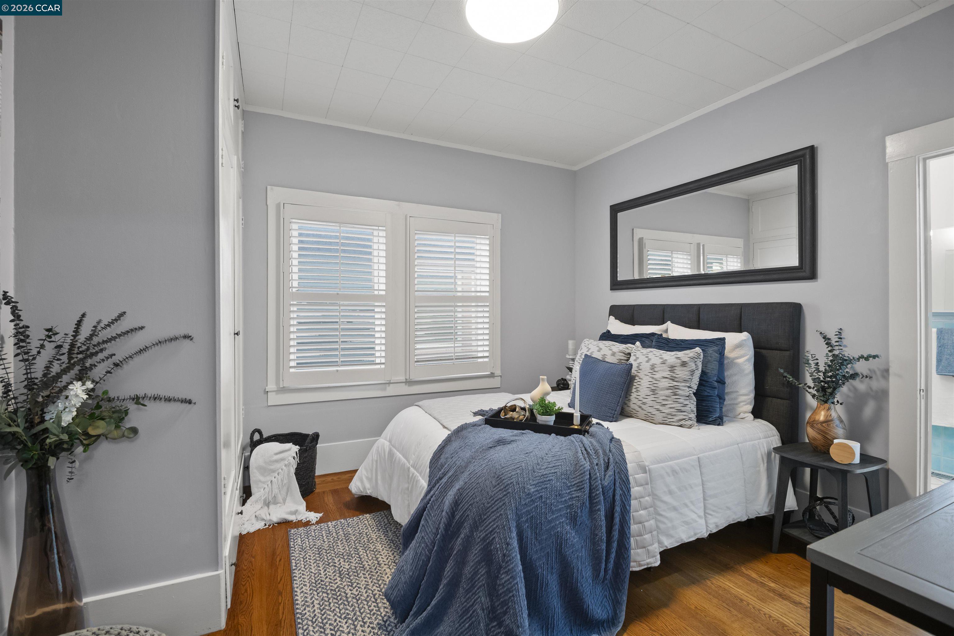 5428 Ruth Avenue Oakland, CA 94601 - Photo 14 of 17 a bedroom with bed and a potted plant